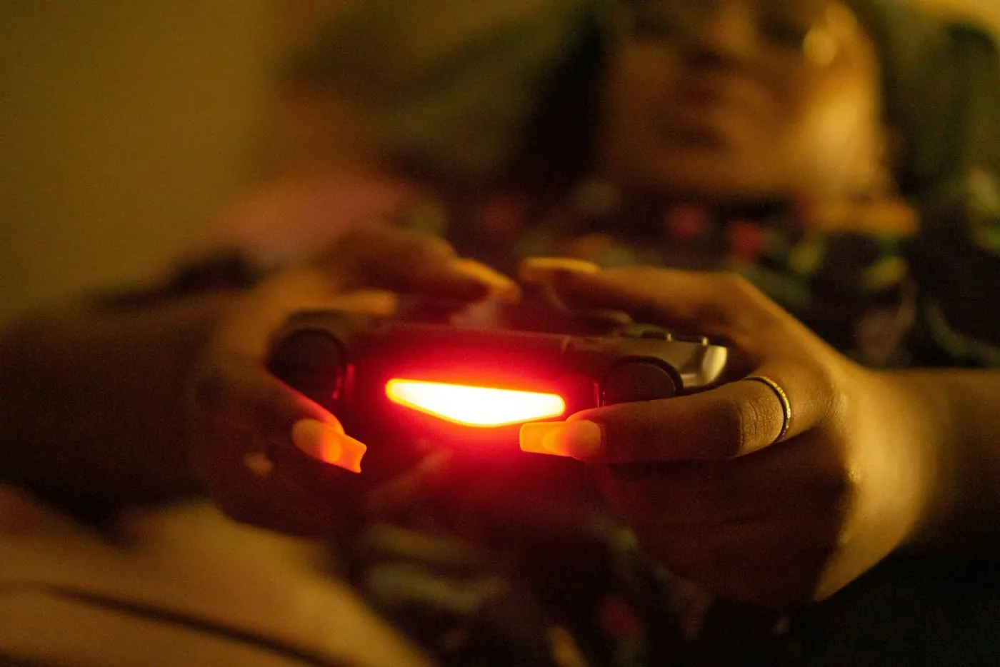 Mains tenant une manette de jeu lumineuse